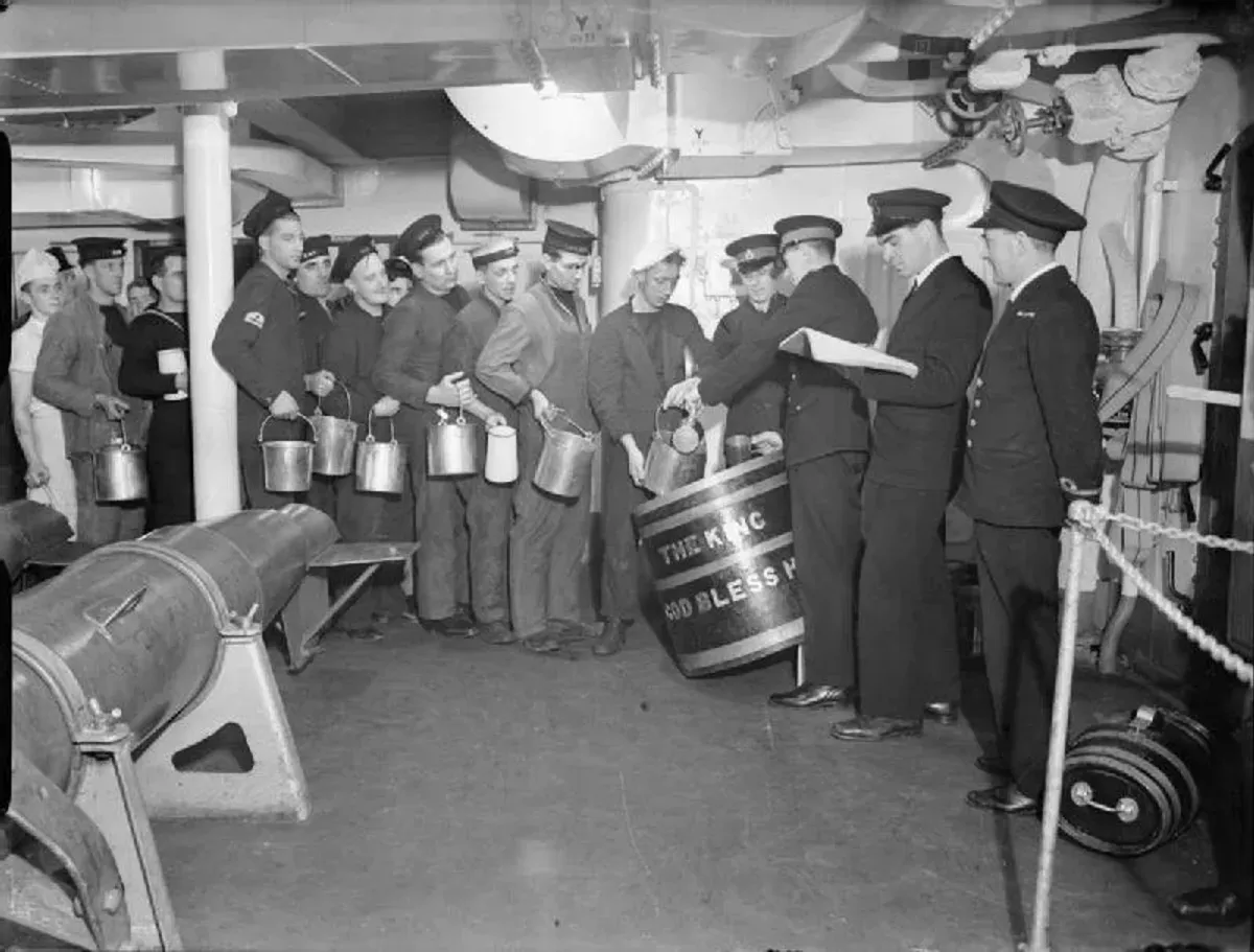 Photographie d'archive de 1940 : distribution de la ration de rhum à bord du cuirassé HMS King George V.